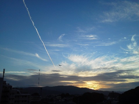 今朝は曇り空だったので，昨夕の我が家からの写真です．夕焼けの空に飛行機雲がきれいでした．それと，ジェット機の小さいシルエット，分かりますか？