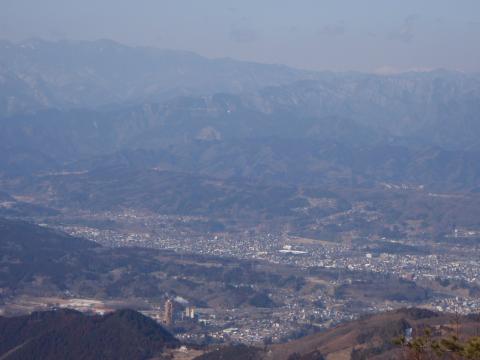 秩父の市街地と、スカイラインは左が奥秩父の甲武信ヶ岳、右の白い山は八ヶ岳の赤岳・横岳。